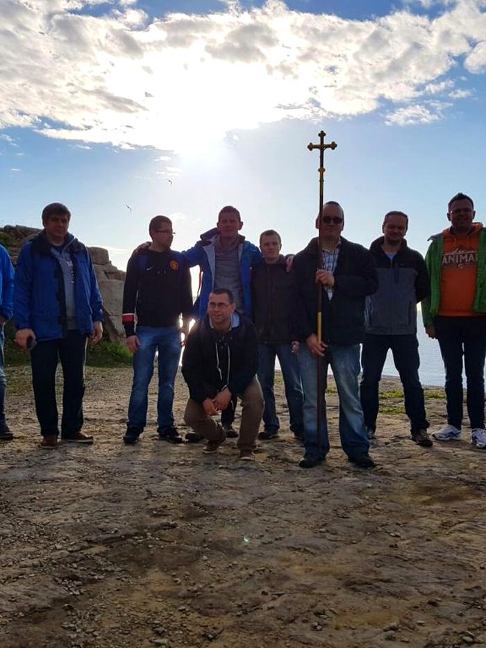 Spacer modlitewny — mężczyźni z krzyżem nad morzem